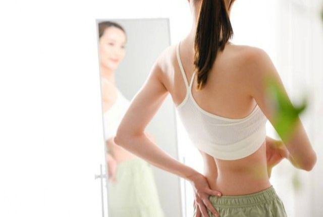 鏡でスタイルをチェックする女性