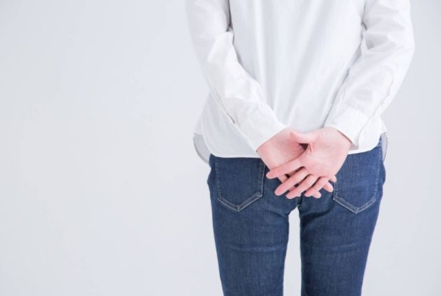 お尻を手で隠す女性